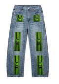 Front view of unisex vintage wash barrel leg denim jeans with green buckle-inspired artwork